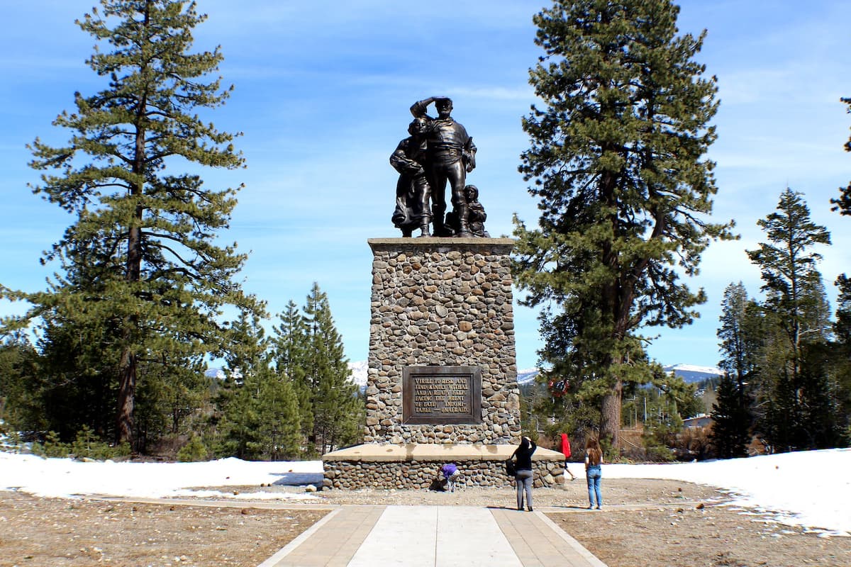 Monument in the Donner Memorial State Park with people in front of it