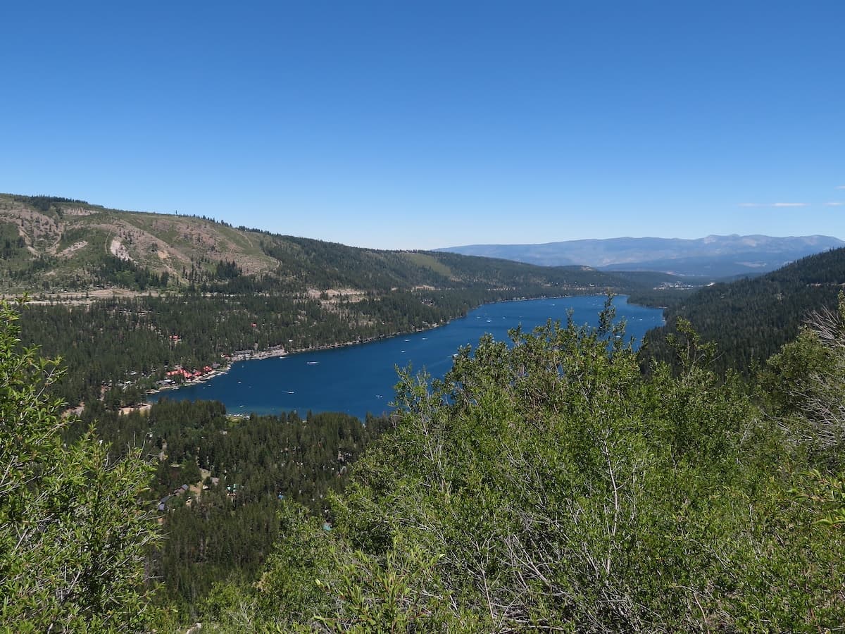 View of Donner Lake from a hiking trail on a clear day with blue skies