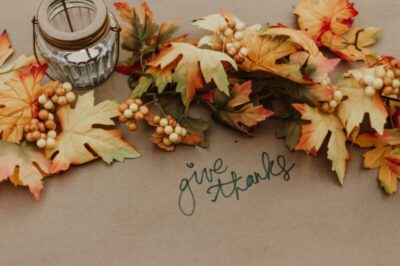 fall leaves with a candle and the words 'give thanks' in cursive - Thanksgiving