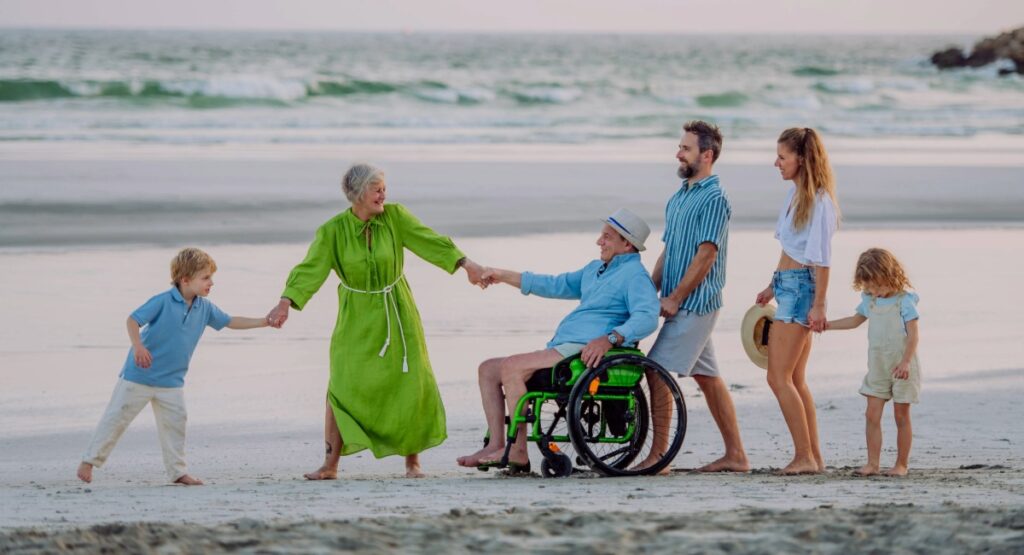 Multi-generational family walking together on Gearhart Beach with wheelchair user, showcasing senior-friendly and accessible Oregon Coast travel