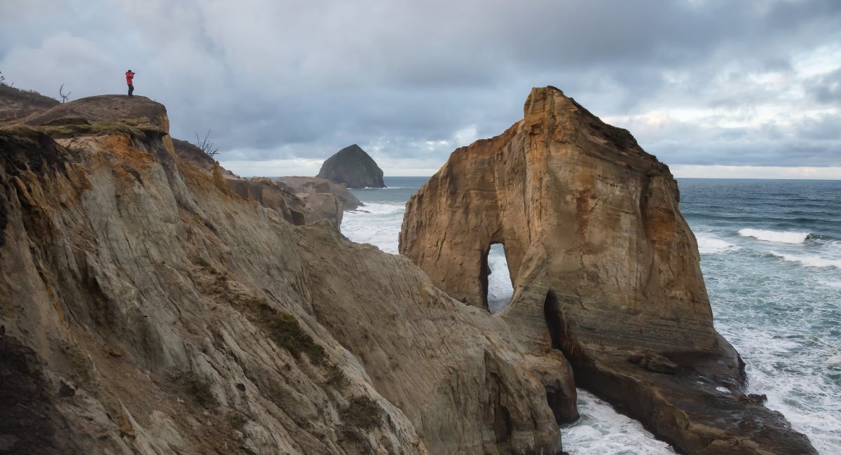 Cape Kiwanda's rugged cliffs with the iconic Haystack Rock in the distance, Pacific City — a serene destination for digital detox and reconnecting with nature.