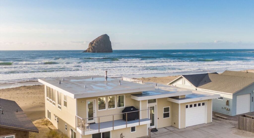 A beachfront vacation rental in Pacific City, Oregon, with a backdrop of the Pacific Ocean, sandy beach, and the chief Kiawanda Rock.