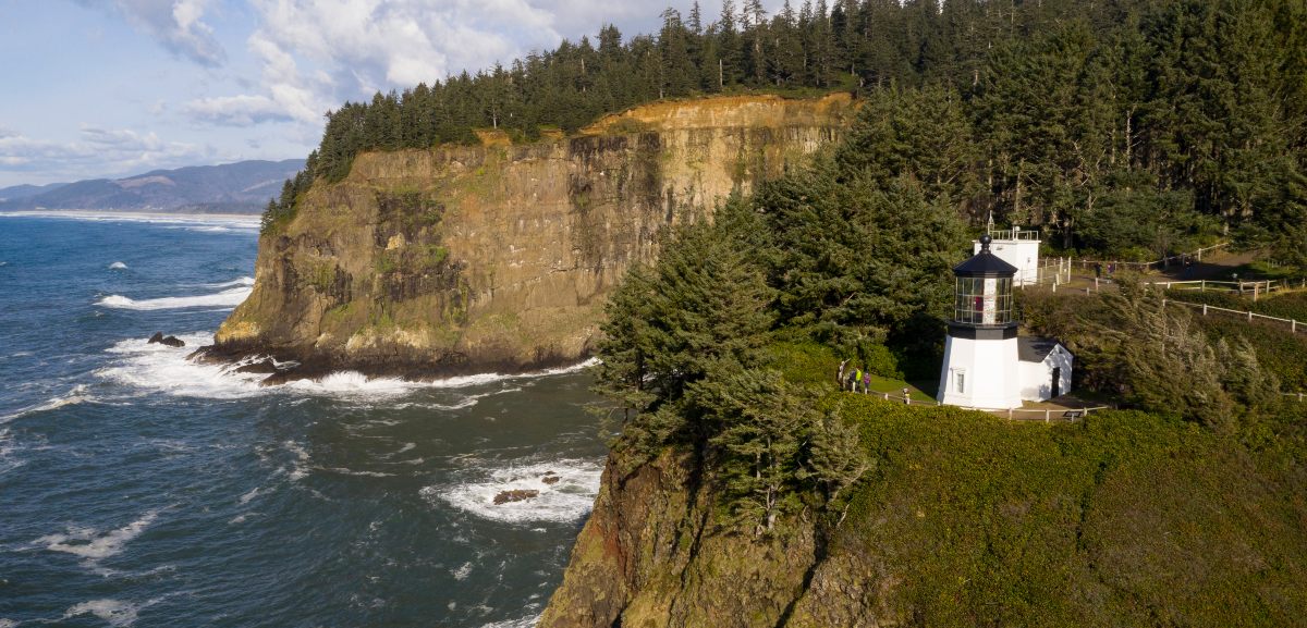 Cape Meares Lighthouse nestled on a high bluff surrounded by dense forest, with breathtaking views of the Pacific Ocean along Oregon’s scenic coastline.