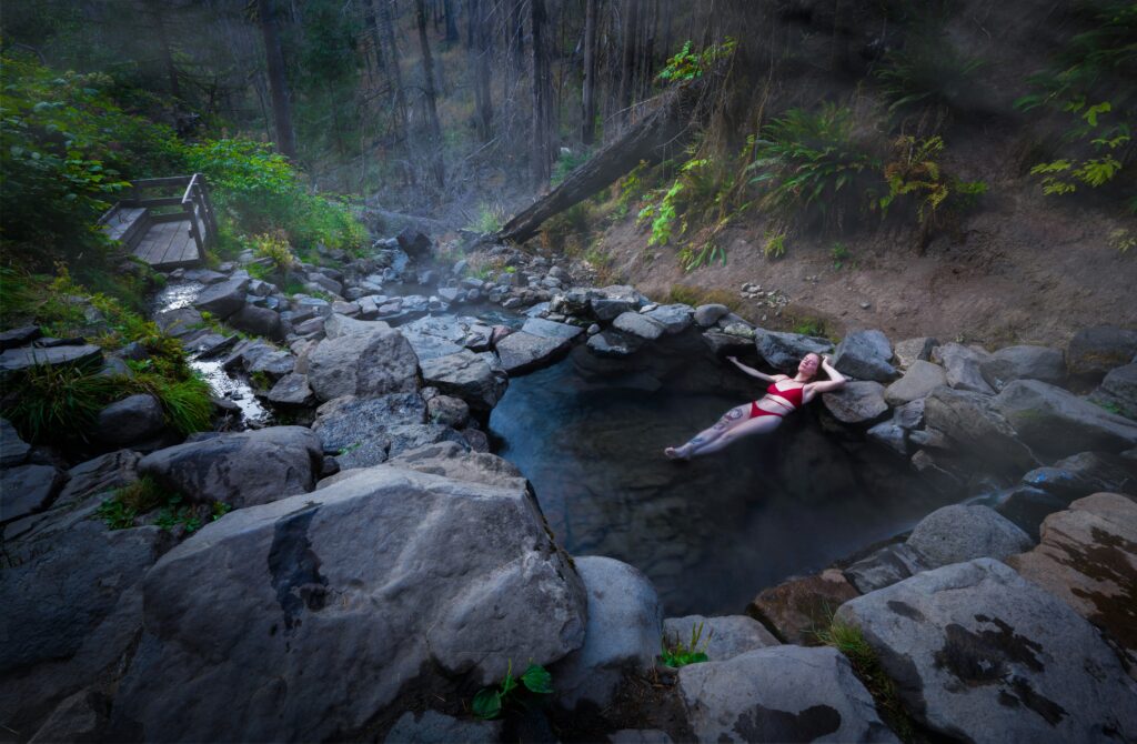 woman in hot tub in a evergreen forest in pacific northwest