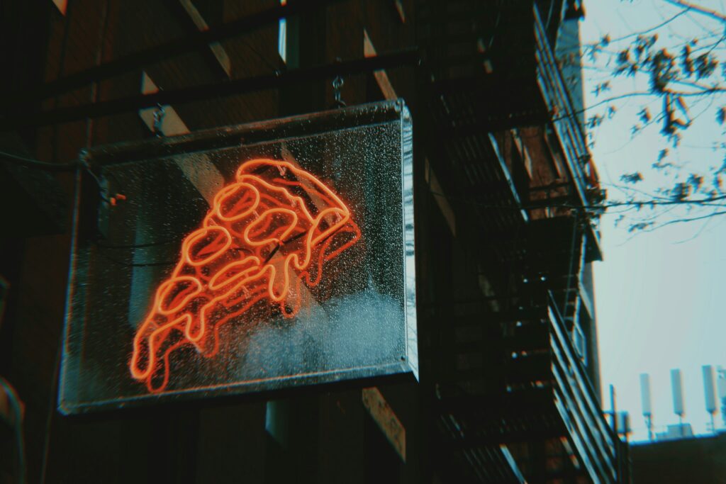 neon sign shaped like a slice of pizza