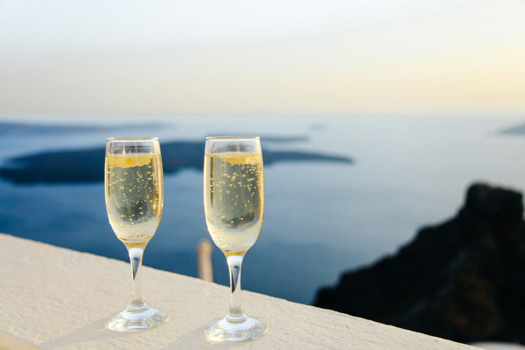 two glasses of champagne on a ledge overlooking the ocean