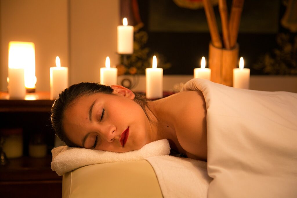 woman relaxing in spa room with candles