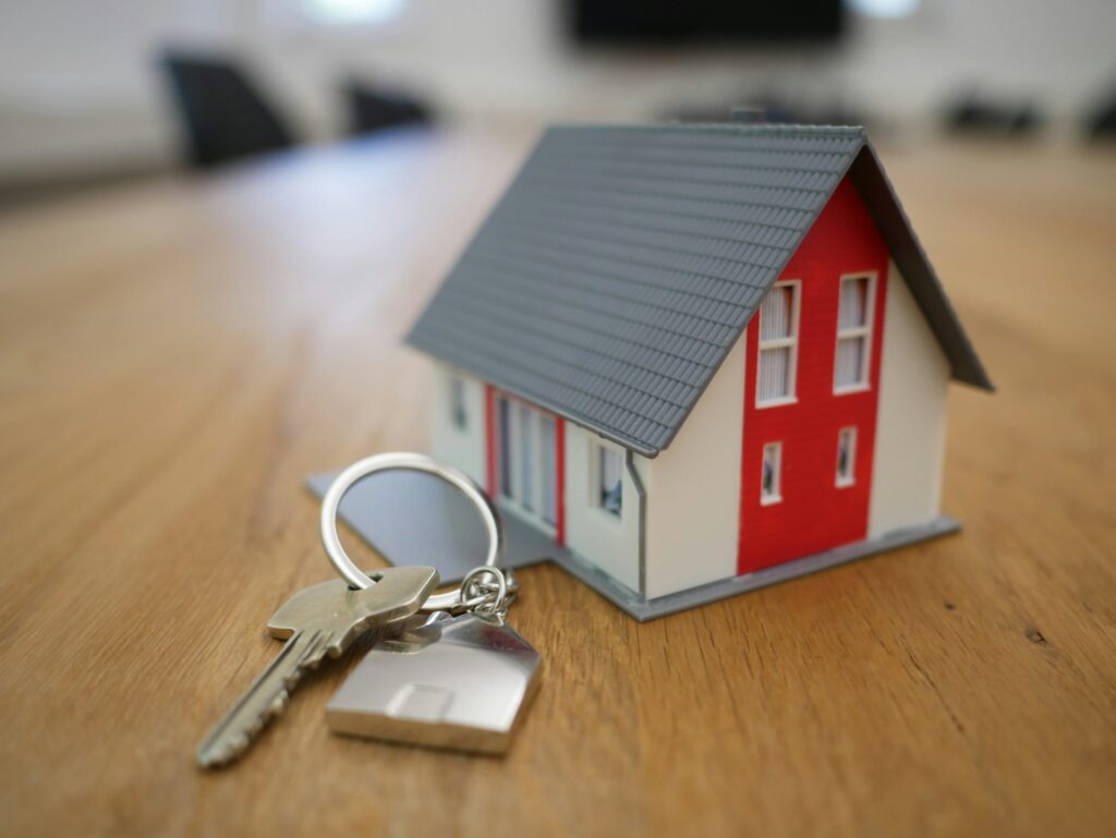 small model of a house and a house key on a table