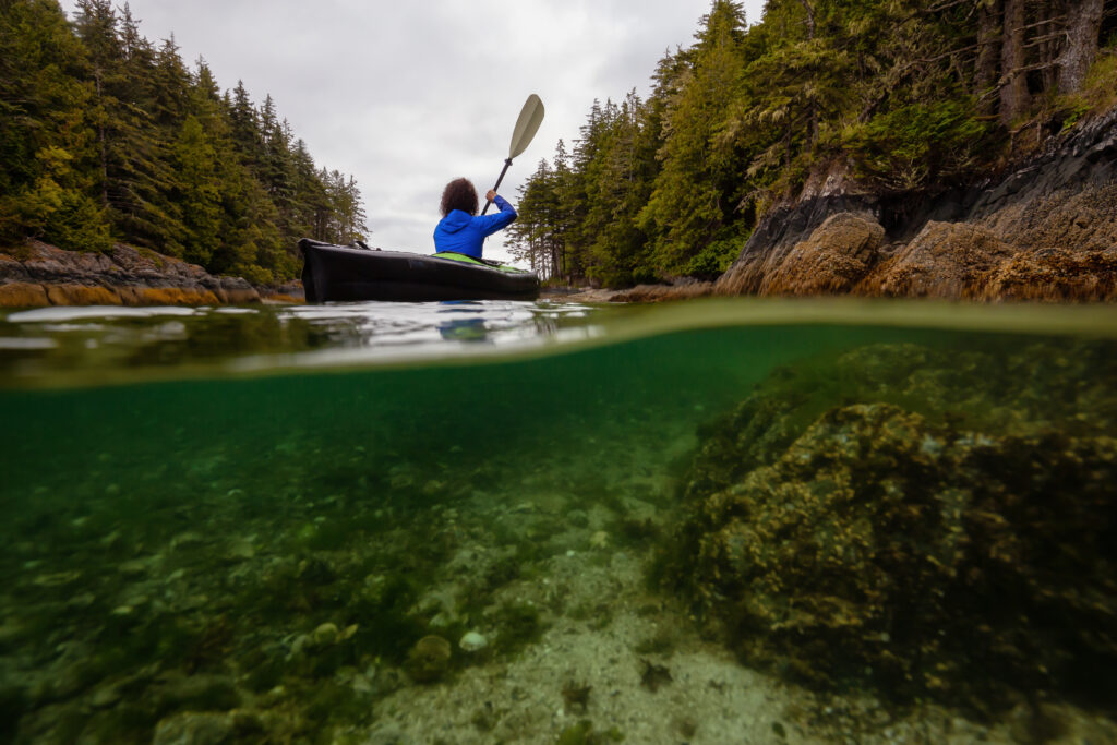 image above and below the water of a kayaker near Vancouver Island